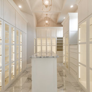 Foto di una grande cabina armadio unisex con ante di vetro, ante bianche, pavimento in marmo e pavimento grigio