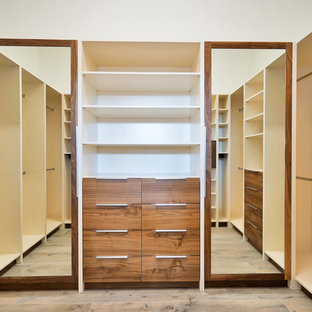 Large minimalist men's laminate floor and brown floor walk-in closet photo in Miami with flat-panel cabinets and dark wood cabinets