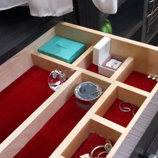 Immagine di una cabina armadio unisex minimal di medie dimensioni con ante di vetro e ante in legno bruno