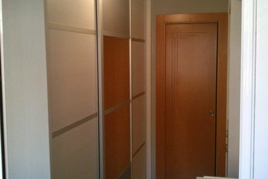 Foto de armario vestidor unisex tradicional renovado de tamaño medio con armarios con paneles con relieve, puertas de armario blancas y suelo de madera clara