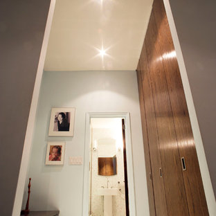 Modelo de vestidor unisex, contemporáneo, de tamaño medio, con armarios con paneles lisos, puertas de armario de madera oscura y suelo de baldosas de cerámica