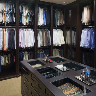 Elegant gender-neutral dressing room photo in Tampa with open cabinets and dark wood cabinets
