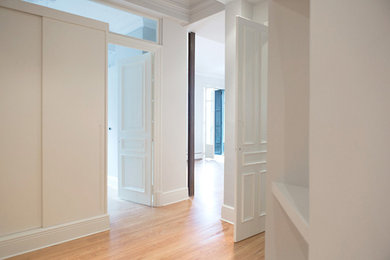 Esempio di uno spazio per vestirsi unisex bohémian di medie dimensioni con ante bianche, pavimento in legno massello medio, ante lisce, pavimento beige e soffitto ribassato