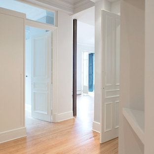Imagen de vestidor unisex, bohemio, de tamaño medio, con puertas de armario blancas, suelo de madera en tonos medios, armarios con paneles lisos y suelo beige