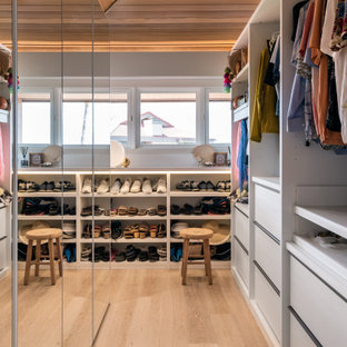 Inspiration för ett litet funkis walk-in-closet för könsneutrala, med luckor med glaspanel, vita skåp, ljust trägolv och beiget golv