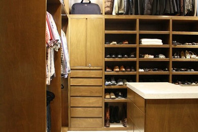 Foto de armario vestidor unisex actual con armarios con paneles lisos y puertas de armario de madera oscura