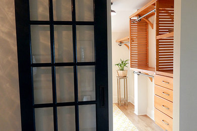 Ejemplo de armario y vestidor de estilo zen con armarios abiertos y puertas de armario de madera clara