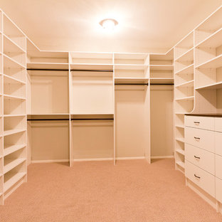 Foto på ett mellanstort amerikanskt walk-in-closet, med släta luckor, heltäckningsmatta, beiget golv och vita skåp