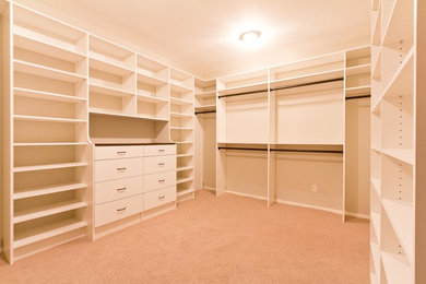 Mid-sized arts and crafts carpeted and beige floor walk-in closet photo in Manchester with flat-panel cabinets and white cabinets