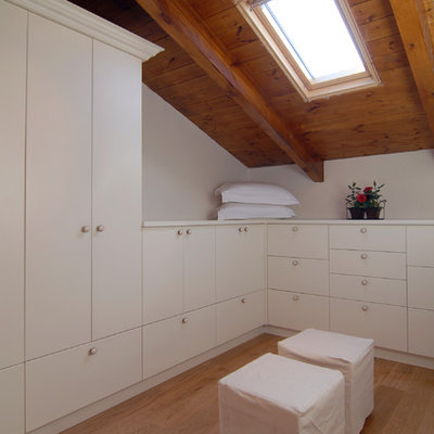 Inspiration for a contemporary light wood floor walk-in closet remodel in Other with white cabinets