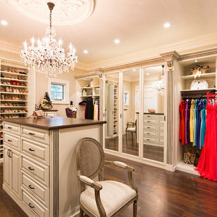 Inspiration pour un grand dressing traditionnel pour une femme avec des portes de placard blanches, un sol marron, un placard avec porte à panneau surélevé et un sol en bois foncé.