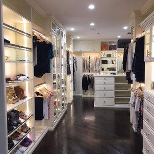 Foto de armario vestidor de mujer, retro, grande, con armarios tipo vitrina, suelo de madera oscura, suelo negro y puertas de armario beige