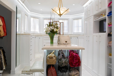 Modelo de armario vestidor unisex clásico grande con armarios con paneles empotrados, puertas de armario blancas, suelo de mármol y suelo blanco
