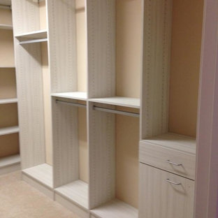Ejemplo de armario vestidor unisex, clásico renovado, con puertas de armario con efecto envejecido y moqueta