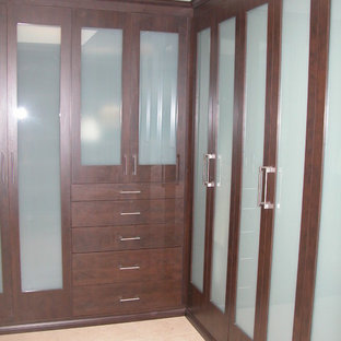 Foto de armario vestidor unisex, tradicional, de tamaño medio, con armarios con paneles empotrados, puertas de armario de madera en tonos medios, suelo de piedra caliza y suelo beige