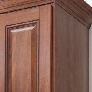 Idee per una cabina armadio tradizionale con ante con bugna sagomata, ante in legno bruno e parquet scuro