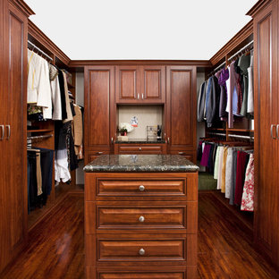 Foto de armario vestidor tradicional con armarios con paneles con relieve y puertas de armario de madera en tonos medios