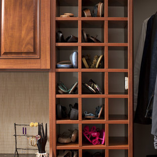 Cette photo montre un dressing chic avec un placard avec porte à panneau surélevé, des portes de placard en bois sombre et un sol en bois foncé.
