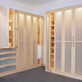 Imagen de armario vestidor unisex, escandinavo, de tamaño medio, con armarios tipo vitrina, puertas de armario de madera clara y moqueta