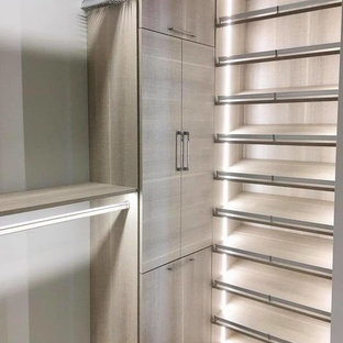 Esempio di una cabina armadio unisex contemporanea di medie dimensioni con ante lisce, ante in legno scuro, pavimento in legno massello medio e pavimento multicolore