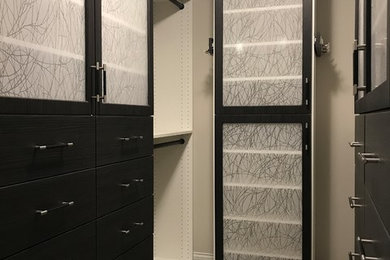 Walk-in closet - mid-sized contemporary gender-neutral carpeted and beige floor walk-in closet idea in Minneapolis with shaker cabinets and dark wood cabinets
