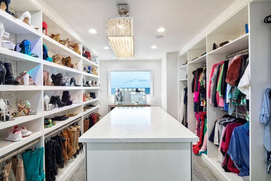 Inspiration for a large contemporary women's gray floor walk-in closet remodel in New York with open cabinets and white cabinets