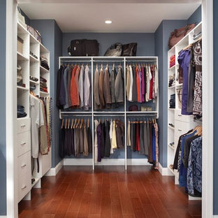 Inredning av ett klassiskt stort walk-in-closet för könsneutrala, med släta luckor, vita skåp, mörkt trägolv och brunt golv