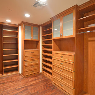 Ejemplo de armario vestidor unisex, actual, de tamaño medio, con armarios con paneles lisos, puertas de armario beige y suelo de madera clara