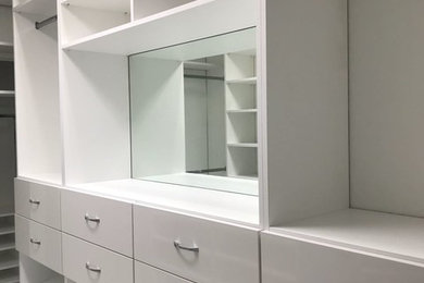 Large contemporary gender neutral walk-in wardrobe in Miami with flat-panel cabinets and white cabinets.