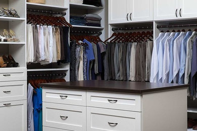 Example of a large classic gender-neutral walk-in closet design in Vancouver with recessed-panel cabinets and white cabinets