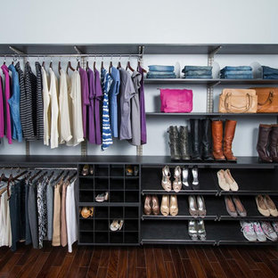 Immagine di una grande cabina armadio unisex moderna con ante lisce e ante nere