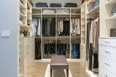 Walk-in closet - large contemporary gender-neutral light wood floor and brown floor walk-in closet idea in New York with flat-panel cabinets and light wood cabinets