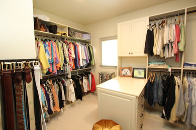 Diseño de armario vestidor unisex de tamaño medio con armarios con paneles con relieve, puertas de armario blancas y moqueta