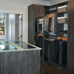 Foto di una cabina armadio unisex chic di medie dimensioni con ante con riquadro incassato, ante con finitura invecchiata, parquet scuro e pavimento marrone