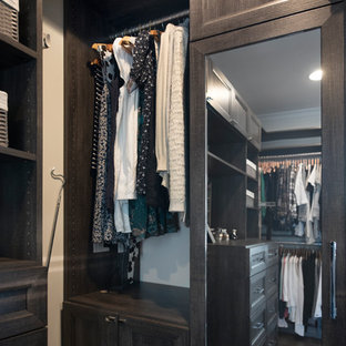 Ejemplo de armario vestidor unisex, tradicional renovado, de tamaño medio, con armarios con paneles empotrados, puertas de armario con efecto envejecido, suelo de madera oscura y suelo marrón