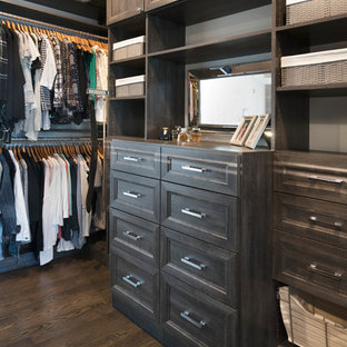 Idee per una cabina armadio unisex classica di medie dimensioni con ante con riquadro incassato, ante con finitura invecchiata, parquet scuro e pavimento marrone