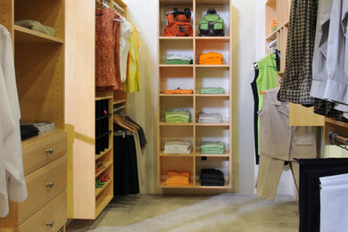 Imagen de armario vestidor unisex tradicional grande con armarios con paneles lisos, puertas de armario de madera clara y moqueta