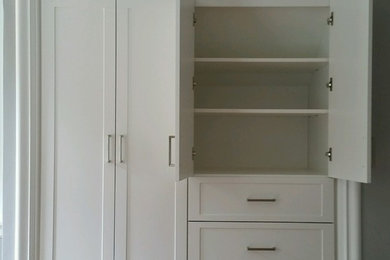 Ejemplo de armario unisex tradicional de tamaño medio con armarios con paneles con relieve y puertas de armario blancas