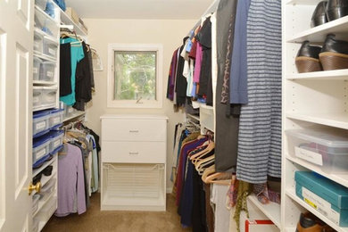 Foto de armario vestidor unisex tradicional renovado de tamaño medio con armarios con paneles lisos, puertas de armario blancas y moqueta