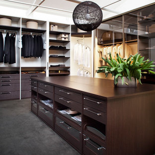 Exempel på ett mellanstort modernt walk-in-closet för könsneutrala, med skåp i mörkt trä, heltäckningsmatta, öppna hyllor och svart golv