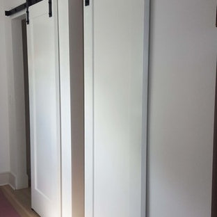 Esempio di armadi e cabine armadio stile marino con ante in stile shaker e pavimento in legno massello medio