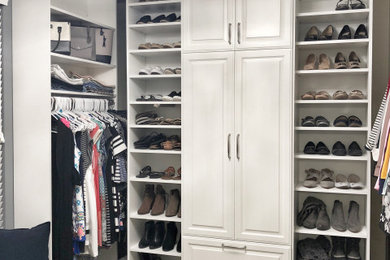 Modelo de armario vestidor clásico renovado grande con armarios con paneles con relieve, puertas de armario blancas, moqueta y suelo beige