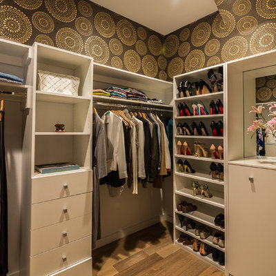 Mid-sized transitional women's medium tone wood floor walk-in closet photo in Los Angeles with white cabinets and flat-panel cabinets