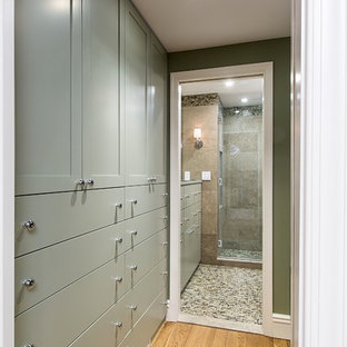 Immagine di una cabina armadio classica con ante con riquadro incassato, ante verdi e parquet chiaro