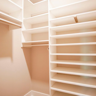 Ispirazione per una cabina armadio unisex industriale di medie dimensioni con ante con riquadro incassato, ante bianche, pavimento in vinile, pavimento marrone e soffitto in legno