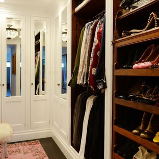 Ejemplo de armario vestidor unisex, bohemio, grande, con armarios con paneles con relieve, puertas de armario blancas, suelo de madera oscura y suelo marrón
