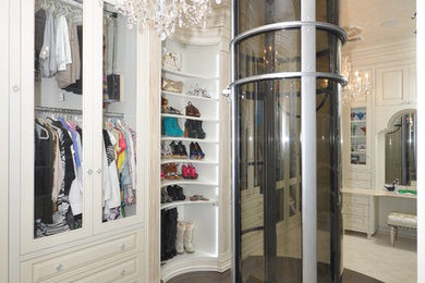 Walk-in closet - large traditional women's dark wood floor walk-in closet idea in New York with white cabinets and raised-panel cabinets