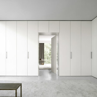Modelo de armario unisex, moderno, grande, con armarios con paneles lisos, puertas de armario blancas y suelo de cemento