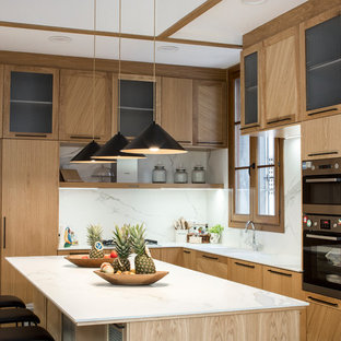 Large transitional u-shaped eat-in kitchen in Barcelona with an undermount sink, raised-panel cabinets, medium wood cabinets, marble benchtops, white splashback, marble splashback, stainless steel appliances, ceramic floors, with island and multi-coloured floor.