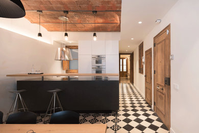 バルセロナにある高級な中くらいなトランジショナルスタイルのおしゃれなキッチン (アンダーカウンターシンク、フラットパネル扉のキャビネット、白いキャビネット、木材カウンター、白いキッチンパネル、クオーツストーンのキッチンパネル、シルバーの調理設備、セラミックタイルの床、白い床、茶色いキッチンカウンター) の写真
